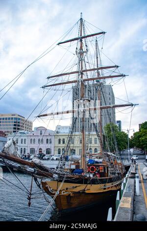 Nave pirata attraccata presso un molo della città con edifici sullo sfondo Foto Stock