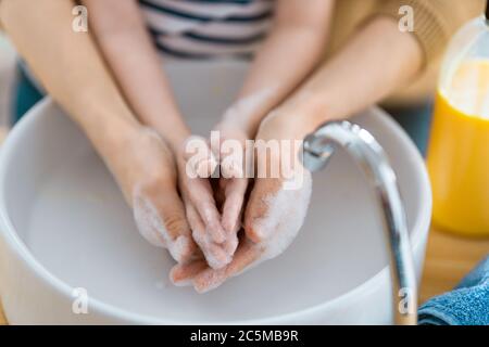 Bambini e adulti si lavano le mani. Protezione contro infezioni e virus. Primo piano. Foto Stock