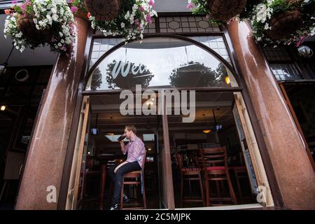 Uno dei primi bevitori alla riapertura del Rochester Castle pub a Stoke Newington, Londra del nord, mentre le restrizioni di blocco del coronavirus sono attenuate in tutta l'Inghilterra. Foto Stock