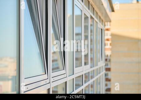 Finestre in PVC sulla facciata del grattacielo. Finestre in plastica a doppio vetro. Esterno dell'edificio. Foto Stock