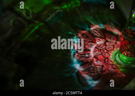 luce che passa attraverso una bottiglia con arte colorata Foto Stock