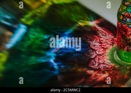 luce che passa attraverso una bottiglia con arte colorata Foto Stock