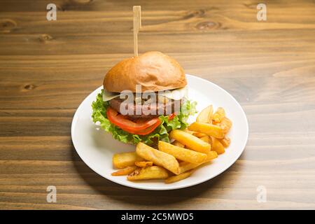 Hamburger di manzo con cipolla caramellata e patatine fritte. Foto Stock