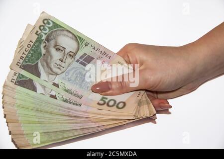 Una mano femminile tiene il denaro ucraino. Hryvnia 500. Bollette ucraine di cinquecento hryvnia. Diverse banconote ucraine in hryvnia. Foto Stock