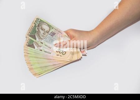 Una mano femminile tiene il denaro ucraino. Hryvnia 500. Bollette ucraine di cinquecento hryvnia. Diverse banconote ucraine in hryvnia. Foto Stock