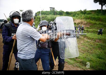 Lalitpur, Nepal. 4 luglio 2020. I locali di Kathmandu, Bhaktapur e Lalitpur si scontrano con la polizia armata e il personale della polizia di Riot durante una protesta per conto del progetto della superstrada Fast-track lungo 76.2 chilometri che parte da Khokana di Lalitpur a Khokana a Lalitpur, Nepal, sabato 4 luglio 2020. Le comunità indigene Newar di Khokana e Bungamati sono preoccupate per i danni che la costruzione di Fast Track potrebbe causare ai loro diritti di proprietà, terra e culturali. Credit: Skanda Gautam/ZUMA Wire/Alamy Live News Foto Stock