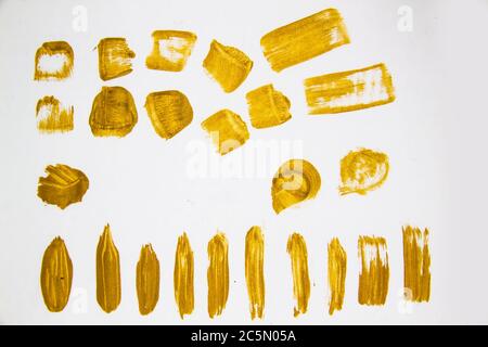 Pennellate di colore oro su sfondo bianco. Golden Abstract Brush marks.Handmade design elements for use.Painted grunge Stripes set for backg Foto Stock