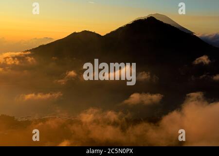 Vista panoramica di nuvole e la nebbia al tramonto dalla cima del monte Batur Kintamani (vulcano), Bali, Indonesia Foto Stock