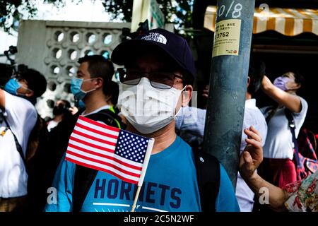 Hong Kong, Cina. 4 luglio 2020. Un uomo detiene una bandiera stampata degli Stati Uniti al di fuori del Consolato Generale degli Stati Uniti, Hong Kong il 4 luglio come gesto di celebrazione e di sfida la legge di sicurezza nazionale di Hong Kong. Credit: Keith Tsuji/ZUMA Wire/Alamy Live News Foto Stock