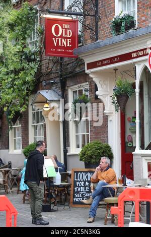 Winchester, Hampshire, Regno Unito. 4 luglio 2020. I pub del Regno Unito riaprono mentre le restrizioni di Coronavirus sono allentate. Gli amici si trovano fuori dal pub Old Vine nella piazza di Winchester. Credit Stuart Martin/Alamy Live News Foto Stock