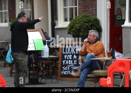 Winchester, Hampshire, Regno Unito. 4 luglio 2020. I pub del Regno Unito riaprono mentre le restrizioni di Coronavirus sono allentate. Gli amici si trovano fuori dal pub Old Vine nella piazza di Winchester. Credit Stuart Martin/Alamy Live News Foto Stock