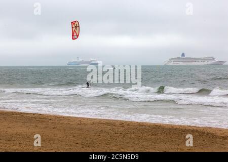 Bournemouth, Dorset UK. 4 luglio 2020. Meteo per il Regno Unito: I kite surfisti possono sfruttare al meglio le condizioni ventose e le onde di una mattina ventosa, frizzante e tortuosa alle spiagge di Bournemouth con la nave da crociera Marella Explorer e le navi da crociera Aurora in lontananza. Kitesurfisti kite surfisti kite surfisti kiteboarders kite boarders kitesurfer kitesurf kite surf kitesurf kitesboarding credito: Carolyn Jenkins/Alamy Live News Foto Stock