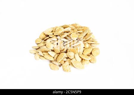 Gruppo di semi di zucca salati in guscio isolato su superficie bianca. Snack cibo pronto a mangiare Foto Stock