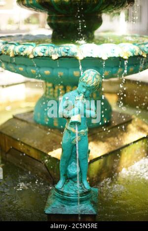 Fontana con ragazzo versa acqua dal vaso. Statua di Cupido Foto Stock