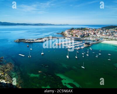 Rocce, barche e piccolo faro nel porto di Portnovo, Galizia, Spagna. Foto Stock