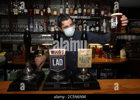 Il bar manager del White Hart Pub di Ironbridge controlla la prima pinta versata mentre riapre per affari, in quanto le restrizioni di blocco del coronavirus sono attenuate in tutta l'Inghilterra. Foto Stock