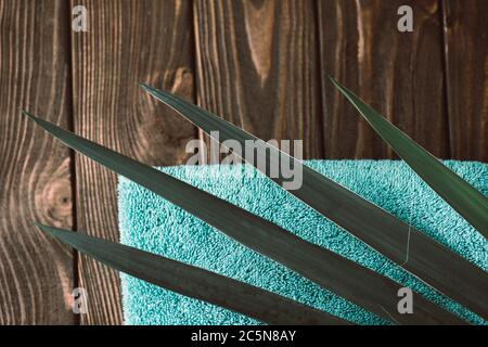 Asciugamani da bagno su sfondo di legno. Asciugamano color menta su tessuto di sfondo scuro Foto Stock