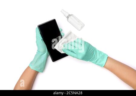 Mani di donna che pulono il telefono cellulare con alcool disinfettante, vista dall'alto su sfondo bianco con tracciato di ritaglio Foto Stock