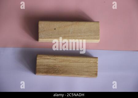 Due blocchi di legno che formano lo stesso segno su sfondo rosa e lilla. Concept di tolleranza, uguaglianza e diversità, concetto di parità retributiva maschile e femminile Foto Stock