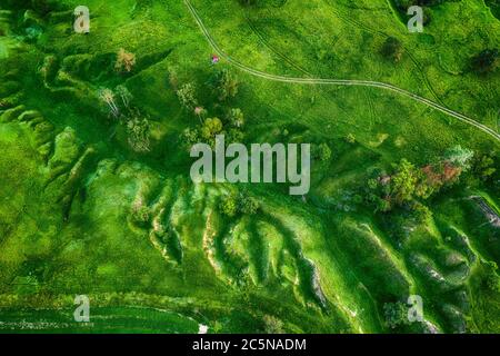 Verdi colline e burroni visti dall'alto, naturale estate sfondo stagionale dal drone Foto Stock