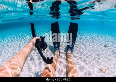 Freediver relax con pinne e maschera sul fondo di sabbia in oceano tropicale subacqueo in Hawaii Foto Stock