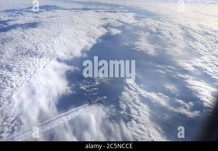 Paesaggio con nuvole dalla finestra di un aereo sulle montagne in inverno sulle Alpi francesi Foto Stock