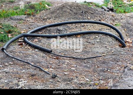 Cavo in un tubo protettivo in PVC sepolto sotto il suolo, comunicazioni per collegare l'elettricità. Foto Stock