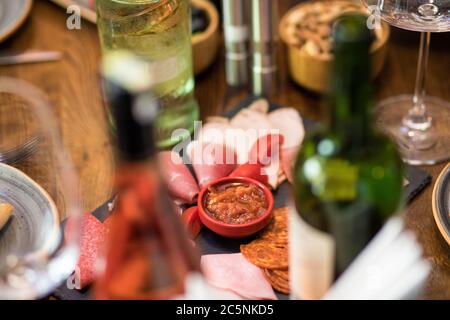 Gustosa salsiccia con pomodoro e salsa con bottiglie di vino Foto Stock