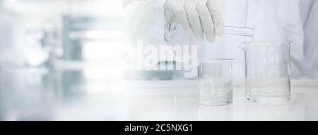 scienziato in bianco cappotto poring acqua in bicchiere di vetro in laboratorio medico scienza banner sfondo Foto Stock