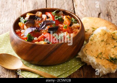 Ricetta Ajapsandali stufato di melanzane, cipolle, pomodori e peperoni dolci primo piano in una ciotola sul tavolo. Orizzontale Foto Stock