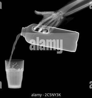 Latte che versa in un bicchiere, raggi X. Foto Stock