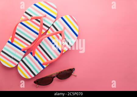 Occhiali da sole e sandali su sfondo rosa in alto Foto Stock