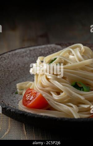 noodle all'uovo cucinato con pomodori e basilico Foto Stock