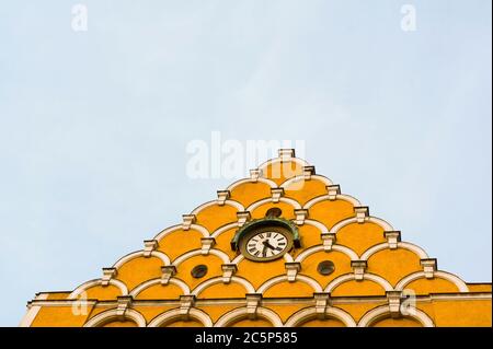 Municipio a Cesky Tesin, Repubblica Ceca / Czecia - decorato muro di edificio. Intonacatura gialla e orologio. Foto Stock