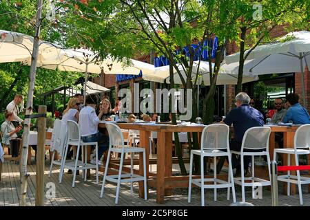 Persone che mangiano all'aperto nel ristorante Warszawa Wschodnia nella fabbrica Soho a Minska 25 nel distretto di Praga. Foto Stock