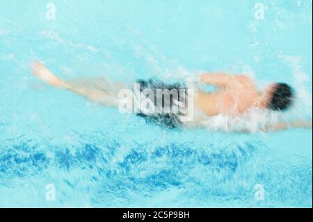 Immagine sfocata dell'uomo che si conteggia nel nuoto libero in una piscina. Vista dall'alto Foto Stock