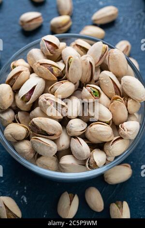 Pistacchi arrosto e salati in una ciotola di vetro Foto Stock