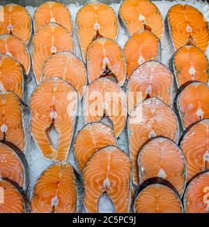 Grandi bistecche di salmone fresco crudo su ghiaccio Foto Stock