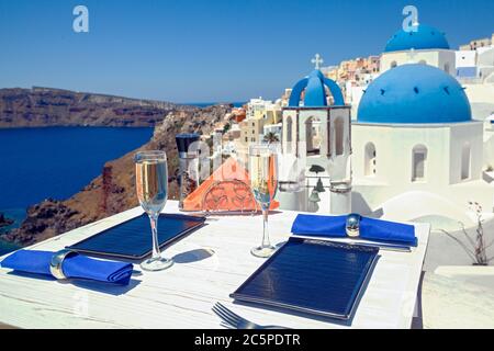 Due bicchieri di vino su un tavolo di legno sullo sfondo dell'isola di Santorini Foto Stock