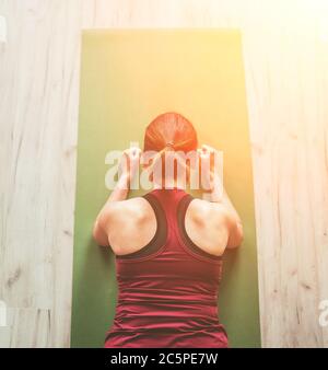 Adatta donna sana sportiva sul tappetino in basso Chaturanga Dandasana yoga posa, facendo esercizi di respirazione, guardando online yoga classe sul computer portatile. Foto Stock