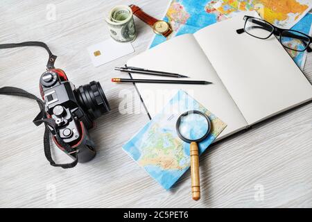 Oggetti personali per viaggiatori. Foto di accessori da viaggio su sfondo di legno chiaro. Foto Stock