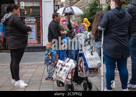 Glasgow, Scozia, Regno Unito. 4 luglio 2020. Le persone in via Buchanan si riuniscono intorno all'artista della palloncino. Il governo scozzese ha annunciato un ulteriore allentamento delle regole del coronavirus durante la fase due di una transizione di quattro parti fuori blocco. Credit: Notizie dal vivo SKULLY/Alamy Foto Stock