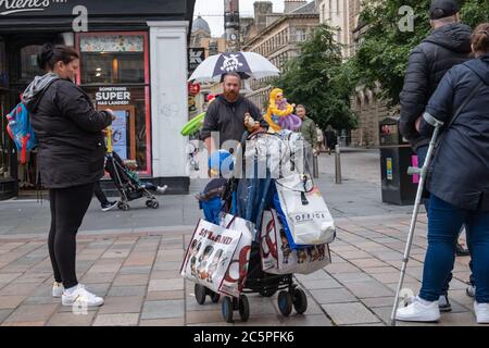 Glasgow, Scozia, Regno Unito. 4 luglio 2020. Le persone in via Buchanan si riuniscono intorno all'artista della palloncino. Il governo scozzese ha annunciato un ulteriore allentamento delle regole del coronavirus durante la fase due di una transizione di quattro parti fuori blocco. Credit: Notizie dal vivo SKULLY/Alamy Foto Stock