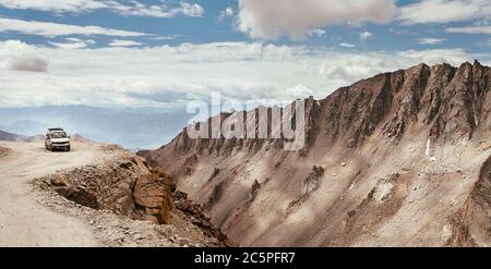 Auto fuoristrada che attraversa il passo di montagna ad alta quota sulla strada Leh - Manali nell'Himalaya dell'India settentrionale, regione del Ladakh. Foto Stock