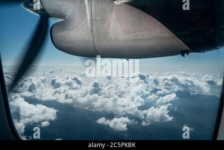 Motore aereo a corto raggio a due motori durante il volo per l'aeroporto di Lukla sulle vette dell'Himalaya. Vista della finestra della cabina dell'aeromobile. Foto Stock