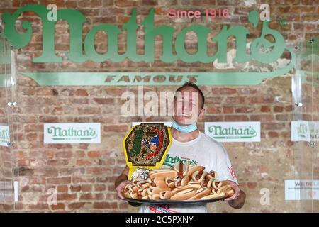 Il mangiatore competitivo Joey Chestnut festeggia dopo aver registrato un nuovo record mondiale con 75 hot dog per vincere la divisione maschile del famoso Concorso annuale Nathan's, il 4 luglio 2020, International Hot Dog-Eating Contest nel quartiere Brooklyn di New York City, NY. La competizione di quest'anno si è svolta all'interno di un edificio senza il pubblico, dove i concorrenti sono stati separati da divisori in plexiglass a causa di preoccupazioni COVID-19, e nel tempo dato di dieci minuti, Chestnut ha consumato 75 hot dog, e Sodo ha consumato 48 hot dog e mezzo. (Anthony Behar/Sipa USA) Foto Stock