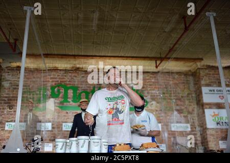 Il mangiatore competitivo Joey Chestnut stabilisce un nuovo record mondiale con 75 hot dog per vincere la divisione maschile del famoso Concorso annuale Nathan del 4 luglio, International Hot Dog-Eating Contest nel quartiere Brooklyn di New York City, NY, 4 luglio 2020. La competizione di quest'anno si è svolta all'interno di un edificio senza il pubblico, dove i concorrenti sono stati separati da divisori in plexiglass a causa di preoccupazioni COVID-19, e nel tempo dato di dieci minuti, Chestnut ha consumato 75 hot dog, e Sodo ha consumato 48 hot dog e mezzo. (Anthony Behar/Sipa USA) Foto Stock