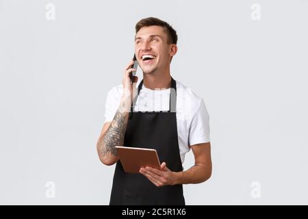 Negozi al dettaglio, piccole aziende, caffè e ristoranti concetto di takeaway. Bell'addetto alle vendite sorridente, barista che parla al telefono, ridendo felice, prendendo Foto Stock