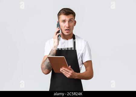 Negozi al dettaglio, piccole aziende, caffè e ristoranti concetto di takeaway. Confuso e preoccupato, il venditore incerto riceve un reclamo dal cliente per telefono Foto Stock