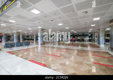 Terminal non utilizzato vuoto, lonuge, banchi di check-in presso l'aeroporto di Tenerife Sud, area partenze, a causa di restrizioni di viaggio per l'epidemia di coronavirus Covid-19. Foto Stock